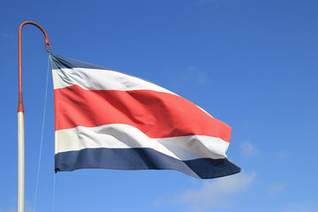 Flag of Costa Rica blue cloudless sky behind