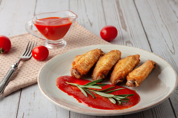 Buffolo wings with tomato sauce and rosemary sprig