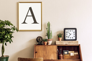 Stylish retro composition of home office interior with vintage wooden cabinet, chair, plants, clock, pendant lamp and elegant accessories. Gold mock up poster frame. Retro home decor.