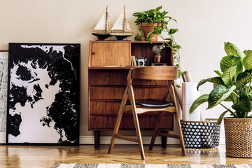 Stylish and vintage interior design of living room with wooden retro commode, chair, tropical plants, ships and elegant personal accessories. Mock up poster frame on the floor. Template. Home decor.