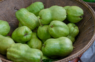 Close up fresh Guavas in wicker basket that Thai fruit gardener put for sale. Fresh organic pile of Guavas in wicker basket.