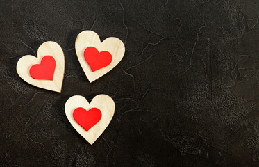 Obraz premium Valentine's day romantic concept. Red wooden hearts on black background.
