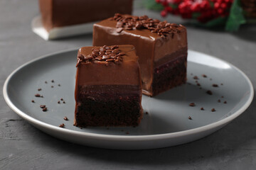 Chocolate brownie with raspberry confit and coffee mousse covered gourmet chocolate glaze on a dark gray background. Closeup. Horizontal format
