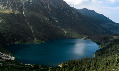 Fototapeta na wymiar Blue lake among forest and mountains
