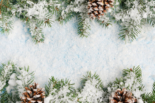 Christmas frame background with snow fir tree and pine cones. copy space for your text