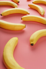 Geometric pattern of bananas on a pink background. The view from the top.