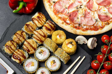 Pizza and sushi rolls tempura and bake rolls on the background of ingredients .Pizza, sushi food photo for menu. Combo set of rolls and pizza.