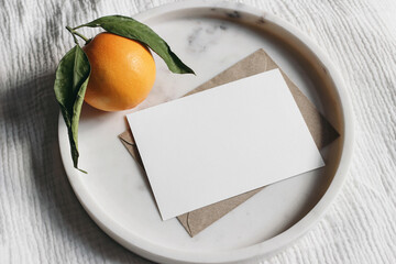 Summer wedding stationery mock-up scene. Blank greeting card, invitation. Craft envelope and orange...