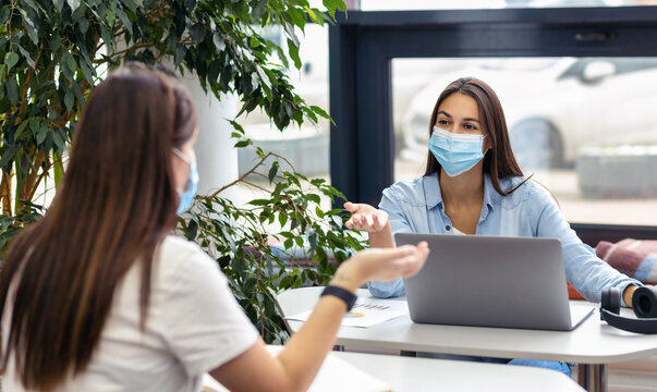 Masked Office Workers Return To Work In Office After Isolation