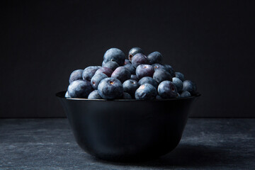 Still life of blueberries on black background and low key