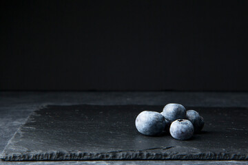 Still life of blueberries on black background and low key