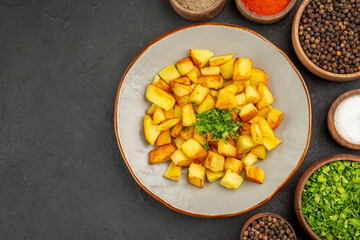 top view tasty fried potatoes inside plate with seasonings on dark desk color food kitchen photo meal