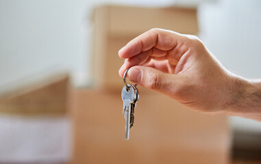 Hand hält Hausschlüssel oder Wohnungsschlüssel