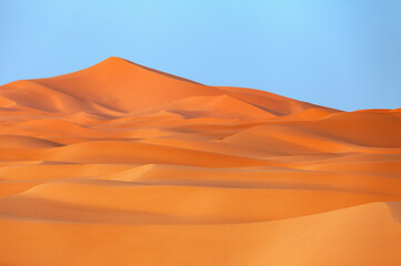 Fototapeta na wymiar Sand dunes in the desert with blue sky background.