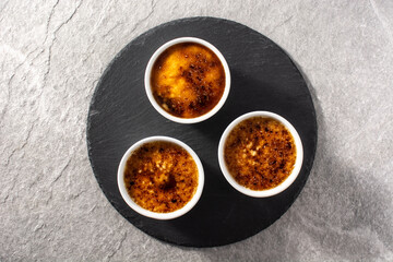 Homemade creme brulee in bowl on gray stone