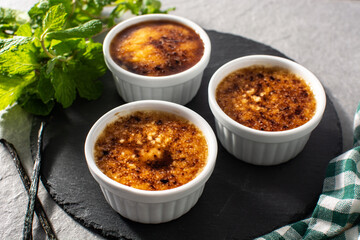 Homemade creme brulee in bowl on gray stone