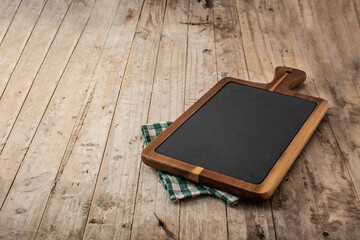 Cutting board mockup and green tablecloth on wooden table. Copy space