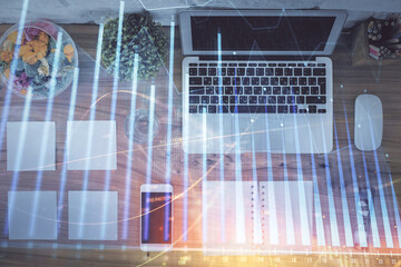 Stock market graph and top view computer on the table background. Multi exposure. Concept of financial education.