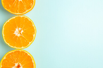 top view fresh tangerine slices on light-blue background color orange photo citrus juice fruit free space