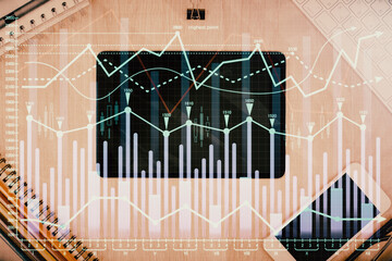 Double exposure of forex graph hologram over desktop with phone. Top view. Mobile trade platform concept.