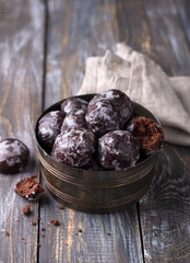 Soft vegan steamed chocolate gingerbread cookies with icing sugar in vintage bowl on wooden table