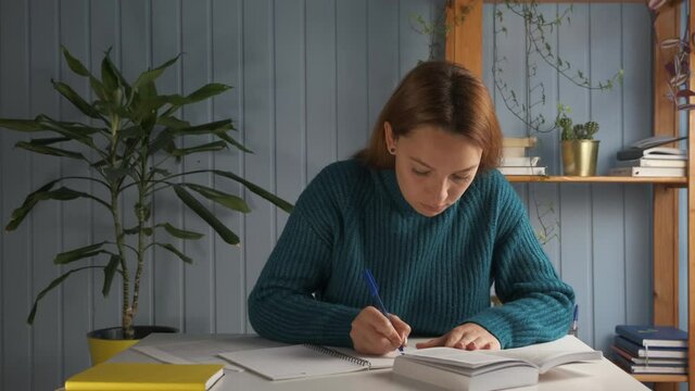 Student girl sitting at desk holds pencil writing essay read textbook, do homework enjoy easy interesting learning process, self-education activity, higher education, gain knowledge, brainwork concept