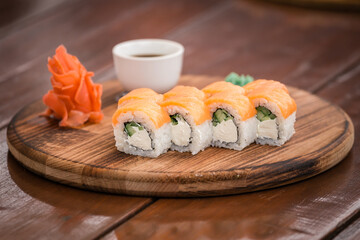 Rolls Philadelphia on a wooden tray on a wooden table on the summer veranda