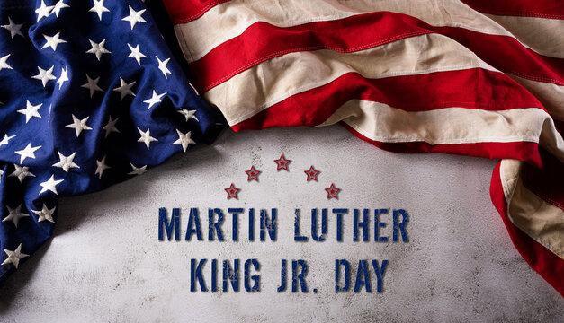 Martin Luther King Day anniversary concept. American flag against dark stone background