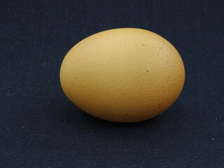 Brown and white eggs against a black background. Organic village eggs provide higher protein