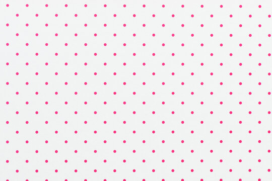 White sheet of paper with pink polka dots. For use as a background or texture.