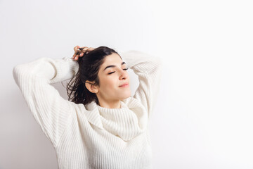 Snowly. Portrait of beautiful brunette woman in comfortable soft longsleeve isolated on white studio background. Home comfort, emotions, facial expression, winter mood concept. Copyspace.