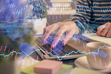 Double exposure of woman hands typing on computer and forex chart hologram drawing. Stock market invest concept.