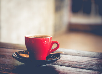 A hot americano is served at a coffee shop, putting on the wooden table.