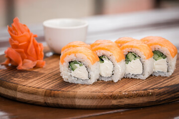 Rolls Philadelphia on a wooden tray on a wooden table on the summer veranda
