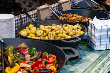 Fast food snack lunch on the street market, a large pan full of fried potatoes and vegetables with meat