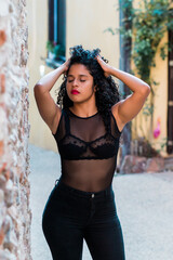 Fototapeta premium young latina woman walking the streets of roanne france, in the background the beautiful houses of the city