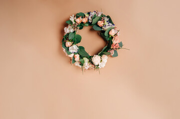 Wreath of flowers on a beige paper background. Top view, flat lay. Christmas floristic concept.
