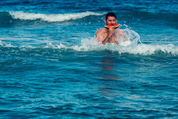 Caucasian man eating piece of watermelon in the sea water Selective focus