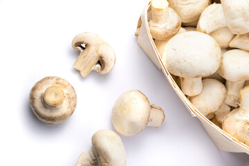 Fresh champignons in a basket isolated on white background.