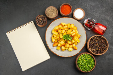 top view tasty fried potatoes inside plate with seasonings on dark background food color oil kitchen photo