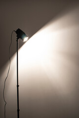 Fototapeta na wymiar The lamp lights the white wall in the dark room