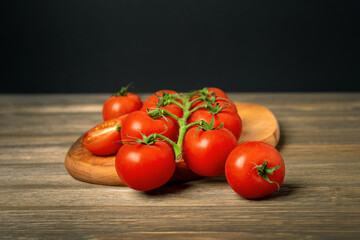 Cherry tomatoes on a branch on a wooden board