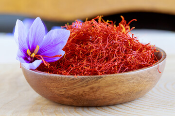 Stigmas of saffron and crocus flower in a wooden plate. cooking saffron spices. Saffron crocus flowers.
