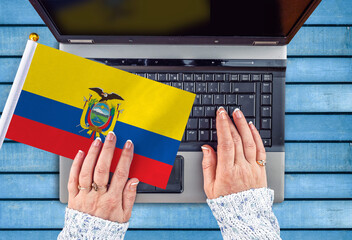 woman hands and flag of Ecuador on computer, laptop keyboard 