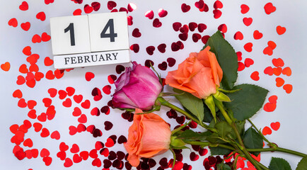 bouquet of flowers strewn with hearts and a wooden calendar with the date of February 14. St. Valentine's Day.