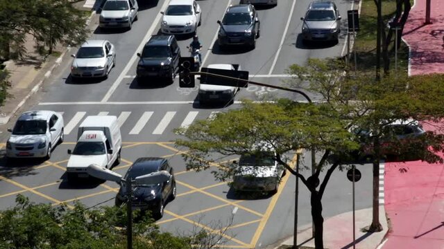 SAO PAULO, BRAZIL - August 2014: Rat race highway traffic in Sao Paulo Brazil moving off as traffic lights change, including cars and buses