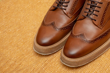 brown leather luxury lace-up shoes for business person, man or woman, on a knitted background. Close-up photo
