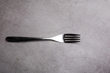 Bright Silver colored fork cutlery isolated on a grey background