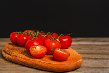 Cherry tomatoes on a branch on a wooden board