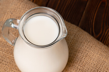 Glass jar of milk on old wooden table